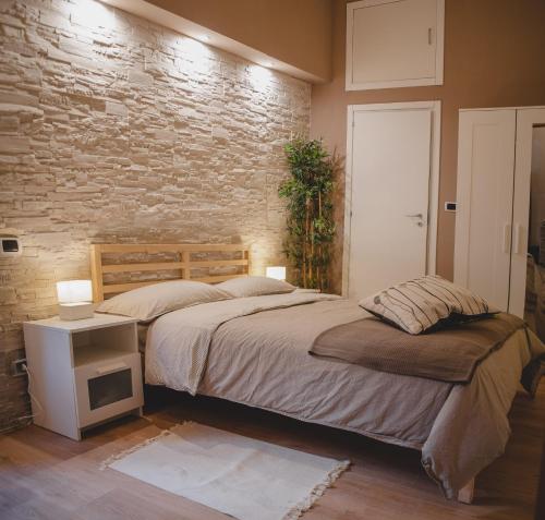 sypialnia z łóżkiem i ceglaną ścianą w obiekcie Casa Lena B&B w mieście Napoli