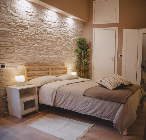 a bedroom with a bed and a brick wall at Casa Lena B&B in Naples