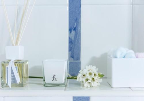 a shelf with glass vases and flowers on it at Fiorentini Residence NAPOLI in Naples