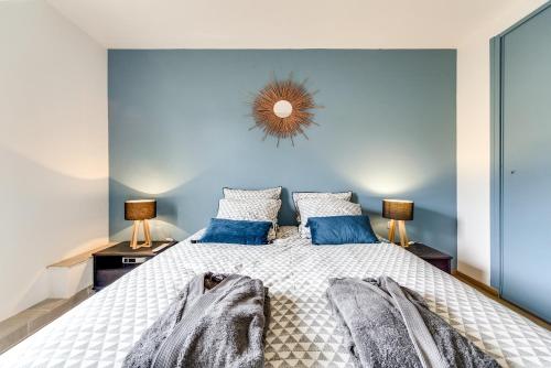 a bedroom with a large bed with blue walls at Le Coin de Marie à deux pas du centre ville in Rambouillet