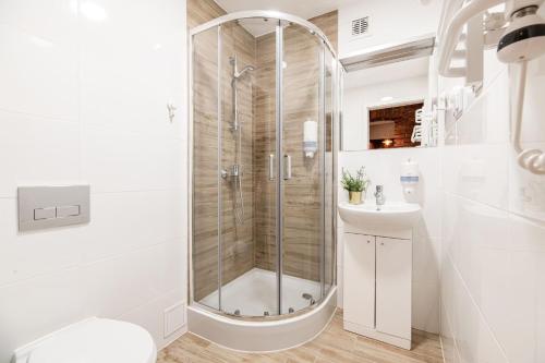 a white bathroom with a shower and a sink at DIETLA 99 APARTMENTS - IDEAL LOCATION - in the heart of Krakow in Kraków