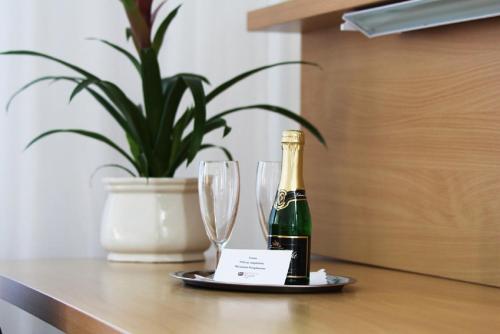 a bottle of champagne and two wine glasses on a table at Hotel Na Pekárně in Sušice