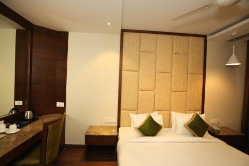 a bedroom with a large bed with a wooden headboard at Maple Grand in Agra