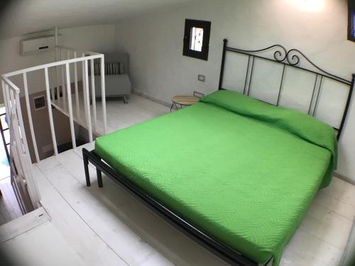 a green bed in a room with a staircase at Villaggio Tamerici IUN Q7142 in San Teodoro
