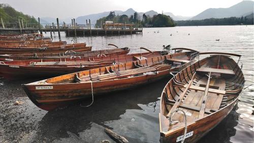 a group of wooden boats sitting in the water at Fern Howe Guest House in Keswick