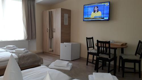 a bedroom with a bed and a tv on the wall at Pensiunea Casa Rusu in Baia Mare