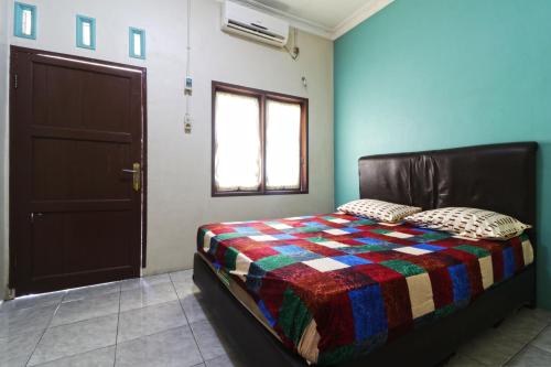 a bedroom with a bed with a colorful quilt on it at Hotel Grand Family in Sungairampah