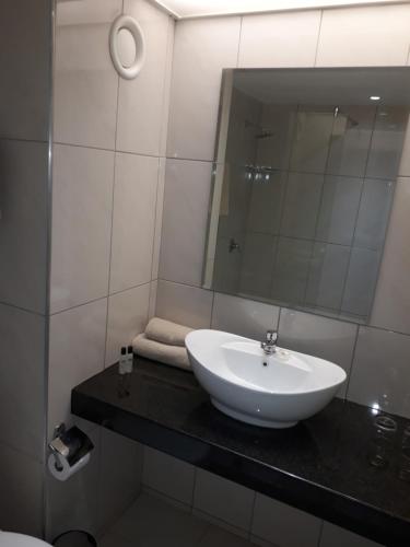 a bathroom with a sink and a mirror at African Sky Hotels - Pine Lake Inn in White River