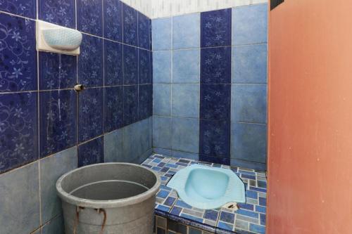 a bathroom with a blue tiled floor with a bucket at Hotel Grand Family in Sungairampah