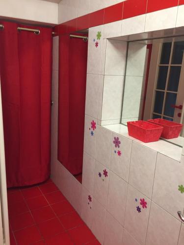 a bathroom with red and white tiles and a red shower at Petit Bijou in Varenna