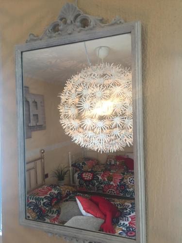 a mirror with a chandelier in front of a bed at Petit Bijou in Varenna