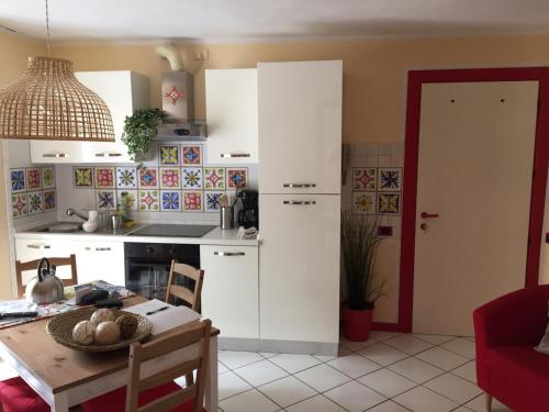 una cucina con mobili bianchi e tavolo di Petit Bijou a Varenna