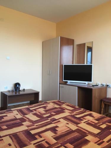 a hotel room with a bed and a flat screen tv at Tonus Guest House in Obzor