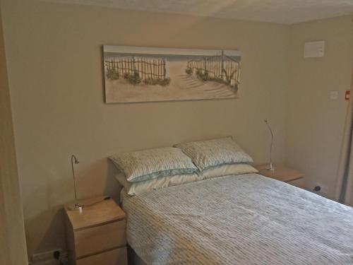 a bedroom with a bed and a painting on the wall at The Loft Guest Apartment in Portstewart