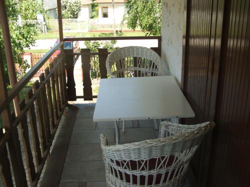 Agancs Vendégház في بالاتونزيم: طاولة بيضاء و كرسيين على شرفة