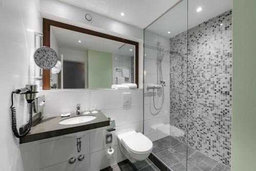 a bathroom with a toilet and a sink and a shower at Mercure Stuttgart Sindelfingen an der Messe in Sindelfingen