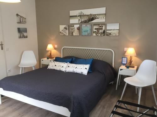 - une chambre avec un lit, 2 chaises et 2 lampes dans l'établissement AUX PETITS BAGANAIS, à Lacanau