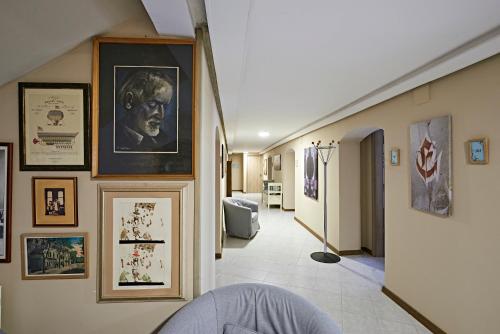 a hallway with portraits and pictures on the walls at Postel Hostel in Balatonfüred