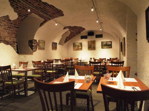 a restaurant with wooden tables and chairs in a room at Arbes in Prague