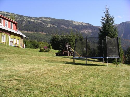 a playground in a field next to a house at Pension 48 in Špindlerův Mlýn