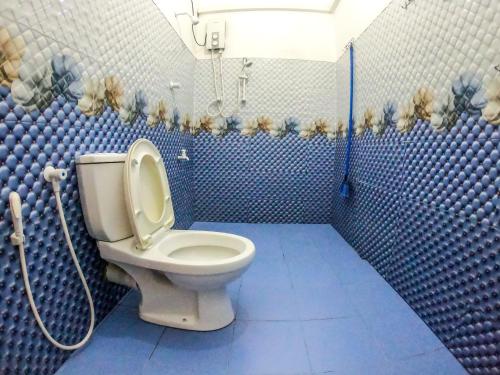 a bathroom with a toilet and a blue tiled wall at Lion Resort in Polonnaruwa
