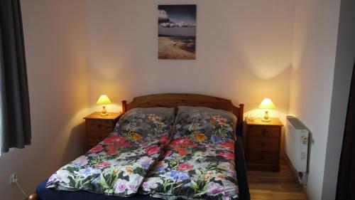 a bedroom with a bed and two night stands with lamps at Ambelia in Stegna