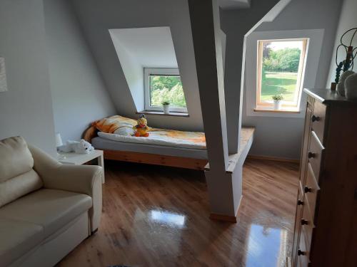 Una pequeña habitación con una cama y dos ventanas. en Apartament Błonia, en Szczecin
