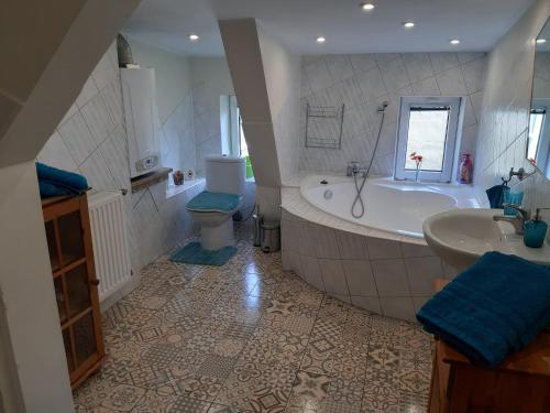 Un baño con bañera, inodoro y lavabo. en Apartament Błonia, en Szczecin
