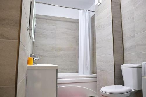 ein Badezimmer mit Toilette, Waschbecken und Badewanne in der Unterkunft Blue Apartment in Spa n Pool Beach resort in Mamaia Nord – Năvodari