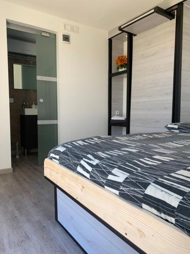 a bedroom with a bed with a black and white comforter at B&B Villa degli Angeli in Bernalda