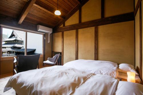 Ένα ή περισσότερα κρεβάτια σε δωμάτιο στο Kariya Ryokan Q