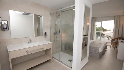 a bathroom with a shower and a sink and a mirror at Hotel Chevy & Suites in Cala Ratjada