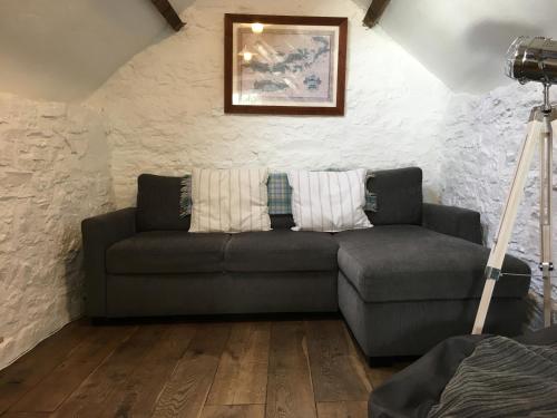 a living room with a gray couch in a room at Little Barn, Greendale Farm in Barnstaple