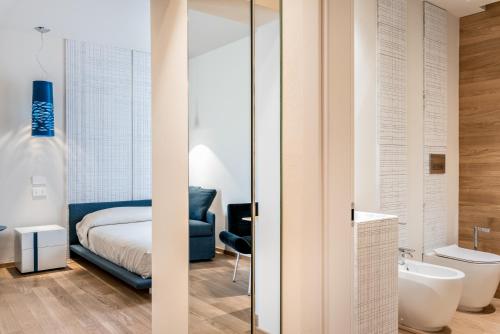 a bedroom with a bed and a bathroom with a tub at Resort Miramonti in Forte dei Marmi