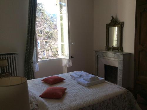 1 dormitorio con 1 cama con toallas y chimenea en Maison Daumas Billard Français et Piscine, en Robion en Luberon