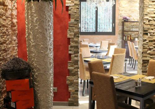 a restaurant with tables and chairs and a red wall at Quattro Gatti Rooms&Suite in Verdello