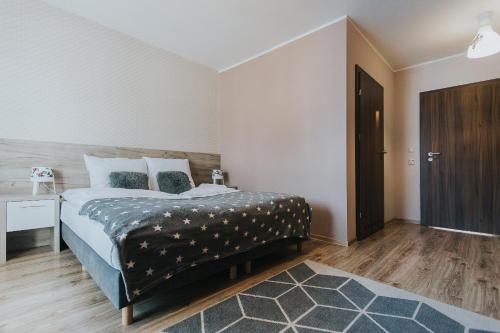 a bedroom with a bed and a wooden floor at Hotel Majerzanka in Piwniczna
