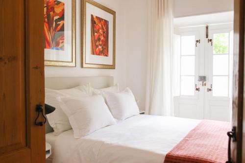 a bedroom with a white bed with white pillows at São Paulo Boutique Hotel - SPBH in Tavira