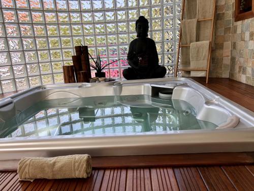 a bath tub in a room with a person sitting in the background at Quinta Da Bela Vista in Ponta Delgada