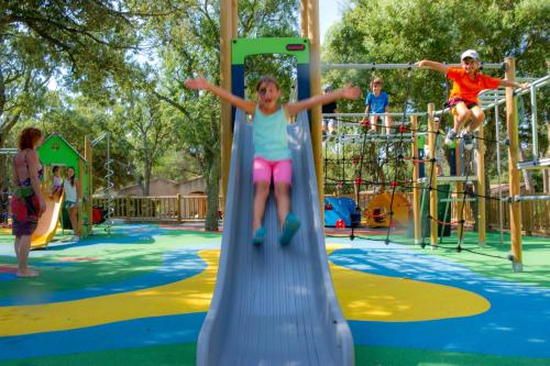 une petite fille sur un toboggan dans une aire de jeux dans l'établissement VTF Le Castelet, à Saint-Aygulf
