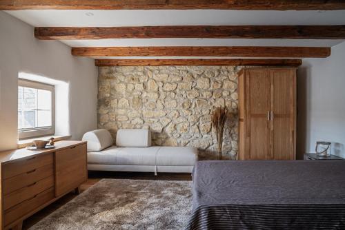 ein Schlafzimmer mit einem Sofa und einer Steinmauer in der Unterkunft Presshaus Schützen in Schützen am Gebirge