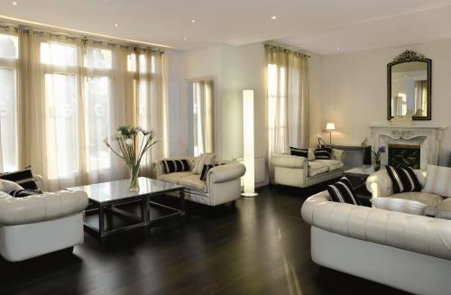 a living room with white furniture and a fireplace at Hotel Villa Paulita in Puigcerdà