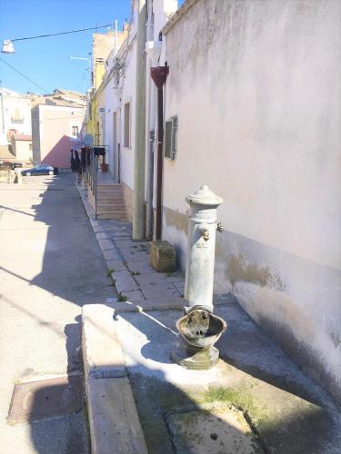 a white fire hydrant sitting on the side of a street at Patanella Wine in Spinazzola