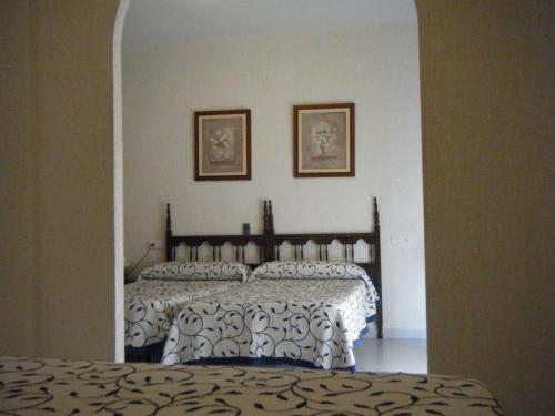 a bedroom with a bed with a white and black comforter at Hostal Muriel in Aljaraque