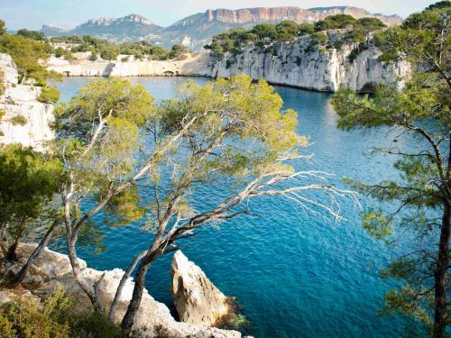 a view of a river with trees and mountains at Mercure Marseille Canebière Vieux-Port in Marseille