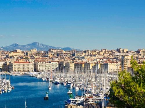 a bunch of boats in a harbor with a city at Mercure Marseille Canebière Vieux-Port in Marseille