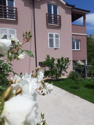 a pink building with white flowers in front of it at Nijona 1 in Trebinje