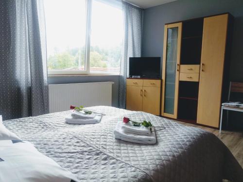 a bedroom with a bed with two baby shoes on it at Noclegi na Heweliusza in Sanok