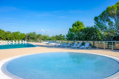 une grande piscine avec des chaises dans l'établissement VTF Le Castelet, à Saint-Aygulf