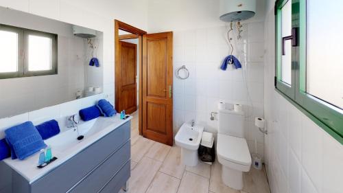 プラヤ・ブランカにあるBlancazul Casa Domingoのバスルーム(洗面台2台、トイレ、バスタブ付)